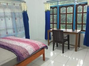 a bedroom with a desk and a table with a chair at Liahz Lodge in Kelimutu +1 photo