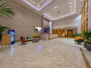 a lobby of a building with furniture and plants at GreenTree Eastern Hotel Jiaxing Jiangnan Moore Store in Jiaxing