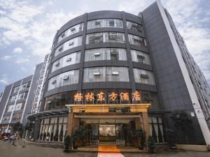 un gran edificio de oficinas con un balcón delante de él en GreenTree Eastern Hotel Anshun Anshun Zhenning Huangguoshu, en Zhenning