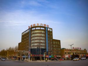 wysoki budynek z znakiem na górze w obiekcie GreenTree Eastern Hotel Hebi Jun County Passenger Station w mieście Xun