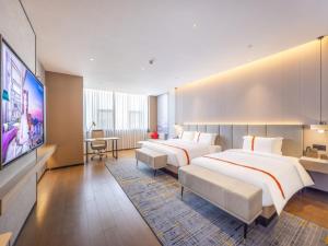 a hotel room with two beds and a flat screen tv at GreenTree Eastern Hotel Lanzhou Zhongchuan Airport Eastern Airlines Center in Lanzhou +50 photos