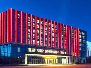 un gran edificio rojo con muchas ventanas en GreenTree Eastern Hotel Hainan Free Trade Port Jiangdong New District Meilan Airport, en Haikou