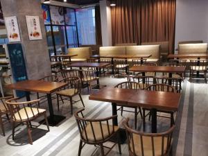 a restaurant with wooden tables and chairs in it at GreenTree Eastern Hotel Ji'an City Suichuan Industrial Park in Suichuan
