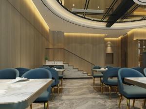 a dining room with tables and blue chairs at GreenTree Eastern Hotel Binzhou Zhonghai International Convention and Exhibition Center in Binzhou
