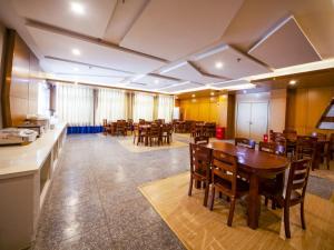duży pokój ze stołami i krzesłami w restauracji w obiekcie GreenTree Eastern Hotel Hebi Jun County Passenger Station w mieście Xun