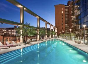 a large swimming pool with chairs and buildings at Spectacular 3BDR & BTH in DTLA with pool, gym and balcony amazing views in Los Angeles