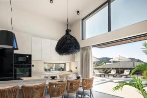 an open kitchen and dining room with a large window at Troia Villas in Bali