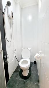 uma casa de banho branca com um WC e um chuveiro em Bels Boarding House (Kost) em Pumpangsineng