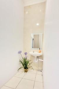 uma casa de banho branca com um lavatório e um espelho em Bels Boarding House (Kost) em Pumpangsineng