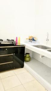 a kitchen with a sink and a stove at Bels Boarding House (Kost) in Pumpangsineng