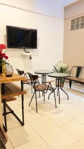 PumpangsinengにあるBels Boarding House (Kost)のテーブルと椅子、薄型テレビが備わる客室です。