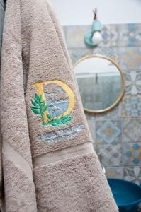 - une serviette brune avec logo dans la salle de bains dans l'établissement Casa Dafne Sorrento Center, à Sorrente