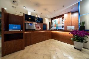 a lobby with a bar with a tv and flowers at Hotel DM in Seoul