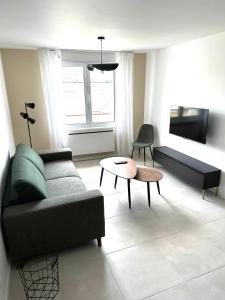 a living room with a couch and a table at Appartement neuf contemporain in Lourdes
