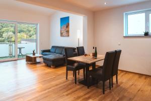 a living room with a table and chairs and a couch at Ferienweingut SerwaziWein in Mesenich