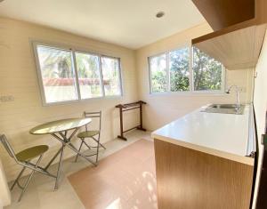 a kitchen with a counter and a sink and two windows at Garden Home Kata in Kata Beach
