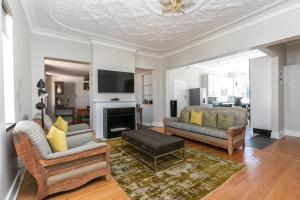 ヨハネスブルグにあるTranquil & Secure 3bed home 2km 2 Emmarentia Damの2つのソファと暖炉のあるリビングルーム