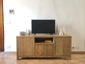 a wooden entertainment center with a flat screen tv on it at CasaMare. Orbetello centro storico. in Orbetello