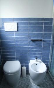 a blue tiled bathroom with a toilet and a sink at CasaMare. Orbetello centro storico. in Orbetello +15 photos
