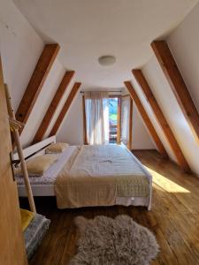 a bedroom with a large bed in a attic at Green Eye in Žabljak