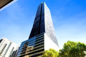 ein hohes Glasgebäude mit blauem Himmel im Hintergrund in der Unterkunft Quick Aces Premium in Melbourne