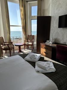 Cette chambre d'hôtel comprend un lit et offre une vue sur l'océan. dans l'établissement Glastonbury Hotel, à Eastbourne