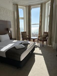 a bedroom with a bed and a view of the ocean at Glastonbury Hotel in Eastbourne