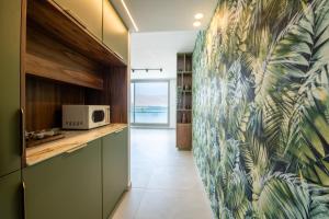 a kitchen with a tropical wallpaper on the wall at Beach Side- Ceasar Luxury Amazing Pool Eilat in Eilat