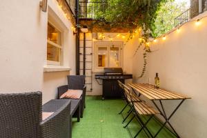eine Terrasse mit einem Tisch und Stühlen sowie einem Schreibtisch in der Unterkunft Niru Experience Hidden Gem in Chelsea in London