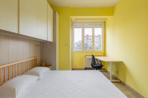 a bedroom with a bed and a desk and a window at Casa Limone by Wonderful Italy in Bologna