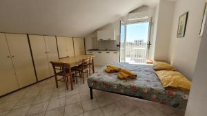 Cet appartement comprend une chambre avec un lit et une table ainsi qu'une cuisine. dans l'établissement Dimora1 MGM, à Marconia