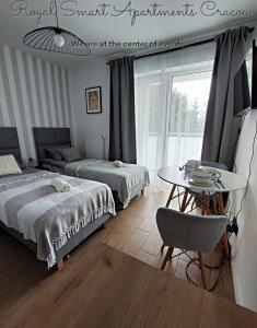 sypialnia z dwoma łóżkami i stołem oraz tableablish w obiekcie Royal Smart Apartments Cracow w Krakowie