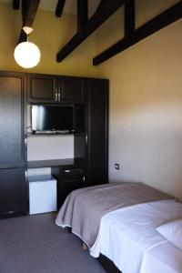 a bedroom with a bed and a kitchen with a microwave at Hotel Vila Bruci in Burrel