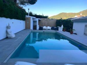 a swimming pool with blue water in a backyard at Villa Amaris in Santa Maria del Tietar