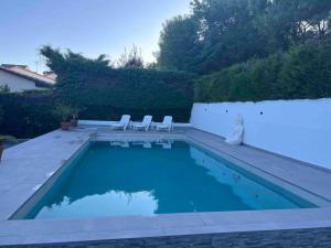 a swimming pool with two chairs at Villa Amaris in Santa Maria del Tietar