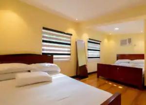 a bedroom with two beds and two windows at CIDNYLAND FARM AND RESORT TANAY in Tanay