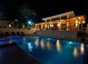 a swimming pool in front of a house at night at CIDNYLAND FARM AND RESORT TANAY in Tanay