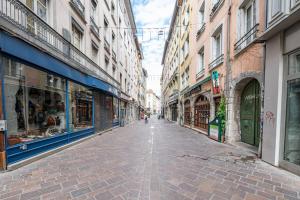 une rue vide dans une ville avec des bâtiments dans l'établissement Entre Bastille et hyper-centre: lave-linge - fibre, à Grenoble