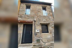 een stenen gebouw met twee ramen en een deur bij Casa Rural Depende in Vilagarcia de Arousa