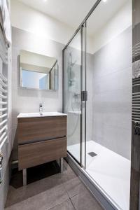 een badkamer met een douche, een wastafel en een spiegel bij Entre Bastille et hyper-centre: lave-linge - fibre in Grenoble
