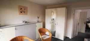 a room with two chairs and a counter and a refrigerator at Fewo Hackländer in Hemmoor