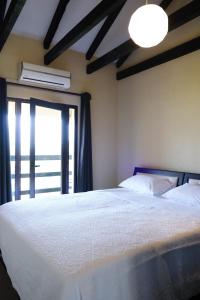 a bedroom with a large white bed with a window at Hotel Vila Bruci in Burrel