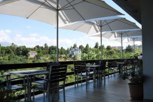 a row of tables and chairs with umbrellas at Hotel Vila Bruci in Burrel