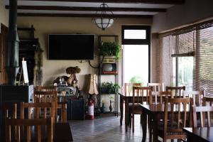 a dining room with a table and chairs and a tv at Hotel Vila Bruci in Burrel