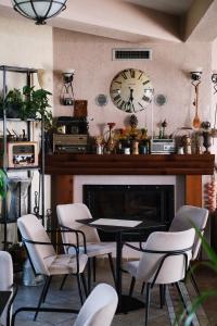 a dining room with a table and chairs and a clock at Hotel Vila Bruci in Burrel