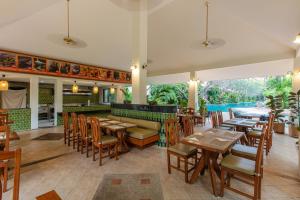 a restaurant with tables and chairs and a bar at Kata Palm Resort - SHA Plus in Kata Beach