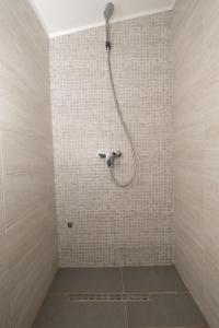 La salle de bains carrelée est pourvue d'une douche avec un tuyau. dans l'établissement Greenoasis Bihac, à Bihać