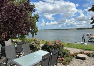 a table and chairs with a view of a lake at Schleiblick App 11 in Rabenkirchen-Faulück