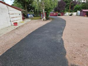 a road that is next to a house at Petite maison in Vendat