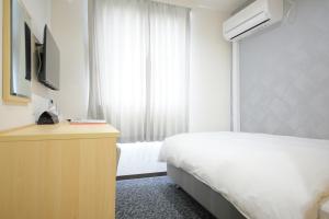 ein Hotelzimmer mit Bett und Fernseher in der Unterkunft Hotel Shin-Imamiya in Osaka